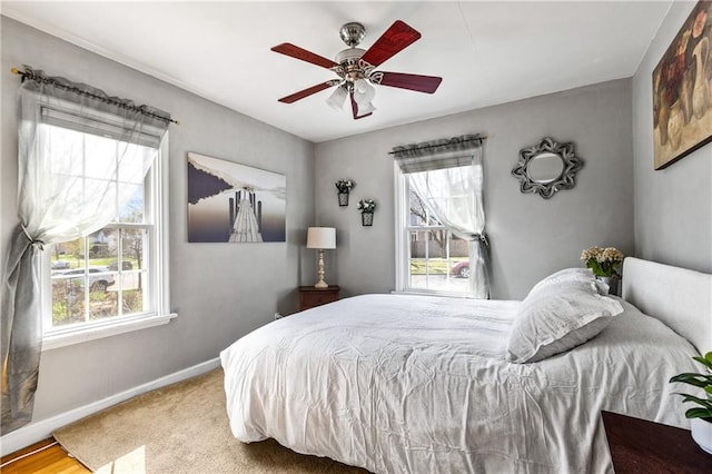 bedroom featuring baseboards, a ceiling fan, and multiple windows