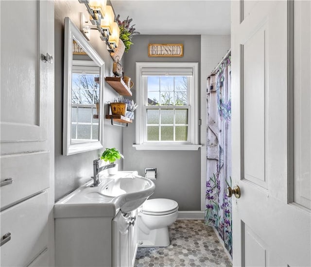 full bath featuring baseboards, vanity, toilet, and a shower with shower curtain