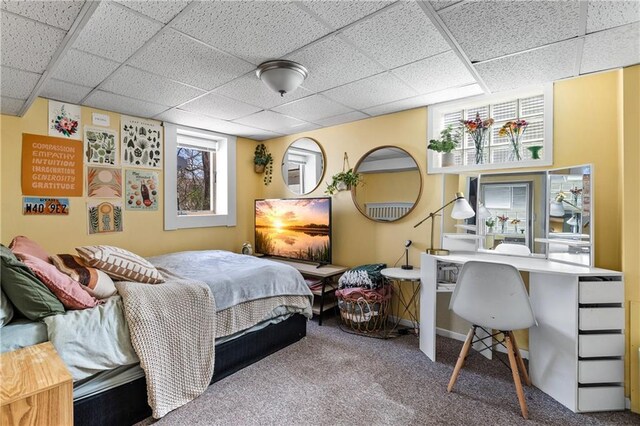 bedroom featuring carpet flooring and a drop ceiling