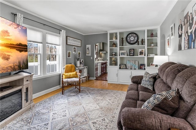 living area with arched walkways, ornamental molding, baseboards, and light wood finished floors