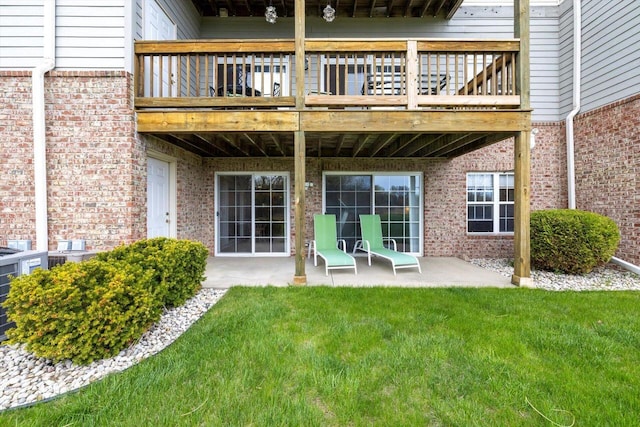 rear view of house with a yard, a patio, and brick siding