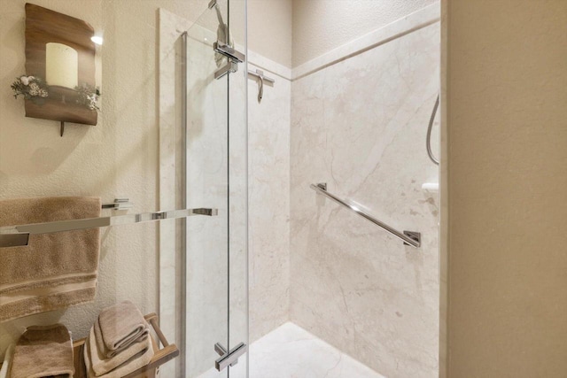 full bathroom with a marble finish shower