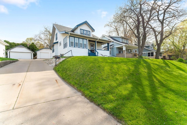 view of front facade with a garage, an outbuilding, covered porch, and a front yard