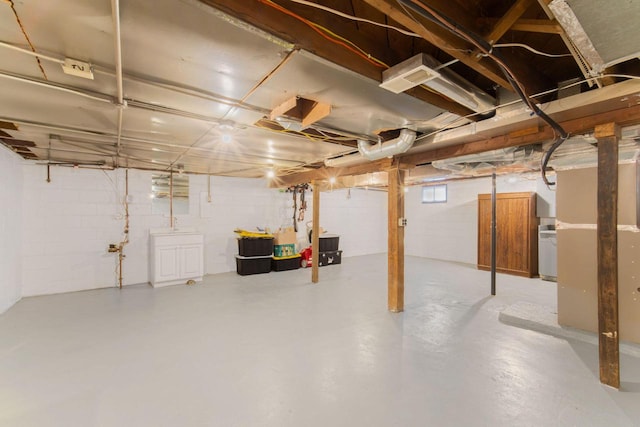 below grade area with washer / clothes dryer and concrete block wall