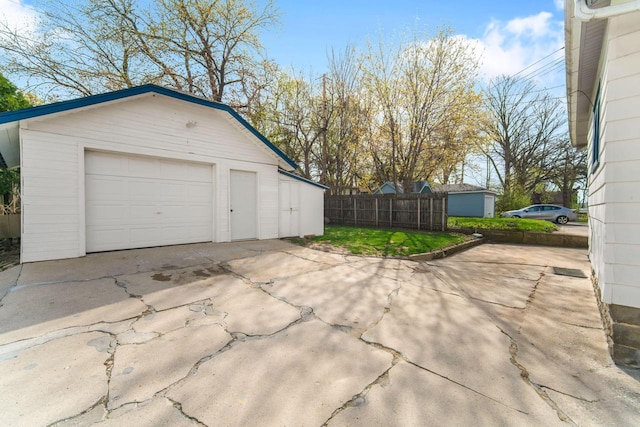 detached garage with fence and driveway