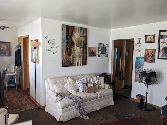 living room featuring a ceiling fan and baseboards