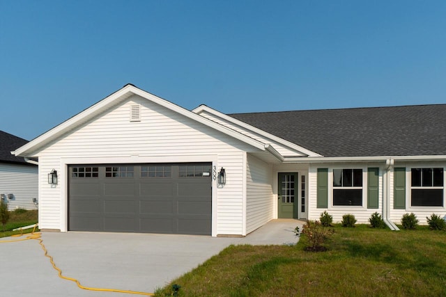 ranch-style house with a garage, a front lawn, roof with shingles, and driveway