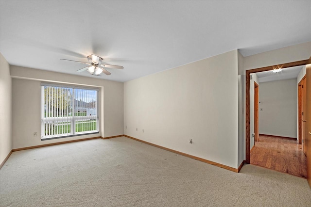 spare room with baseboards, light colored carpet, and ceiling fan