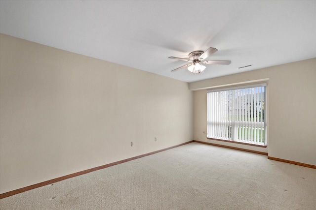 spare room featuring baseboards, a ceiling fan, carpet, and visible vents