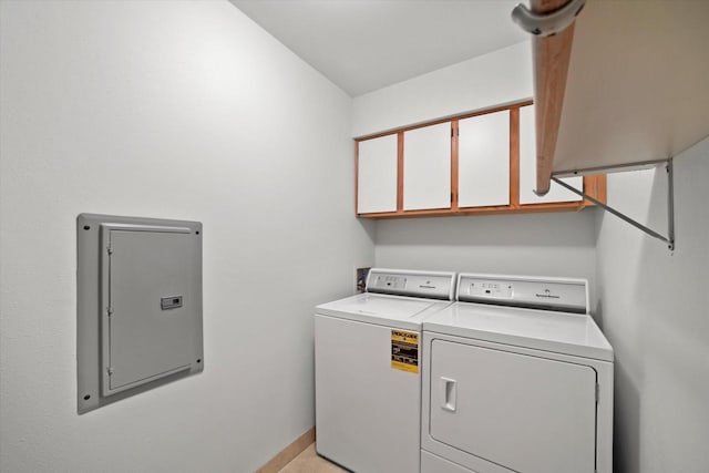 laundry room with cabinet space, baseboards, washing machine and dryer, and electric panel