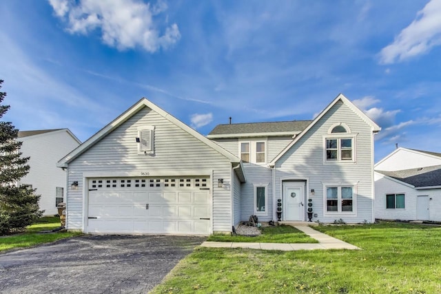 traditional home with a garage, driveway, and a front lawn