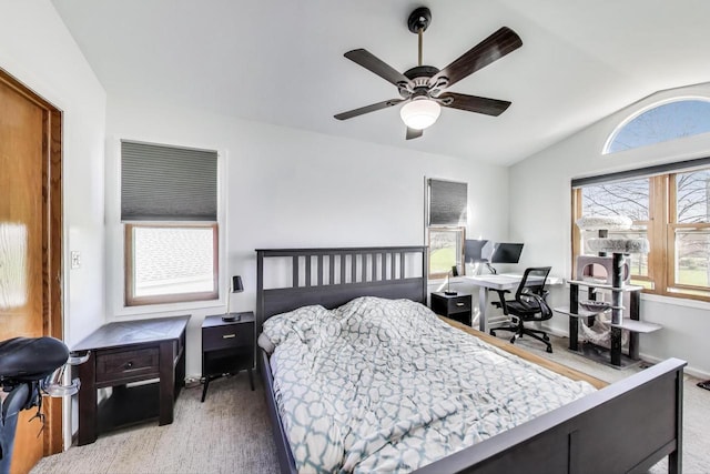 carpeted bedroom with a ceiling fan and vaulted ceiling