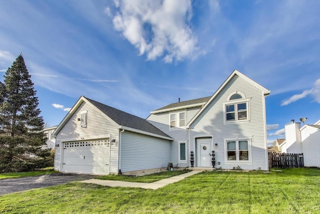 traditional-style house featuring aphalt driveway, fence, a front yard, and a garage