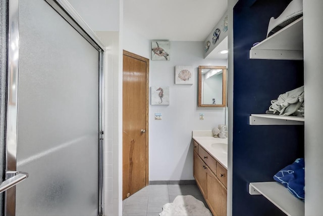 bathroom featuring vanity, baseboards, tile patterned flooring, and a shower stall