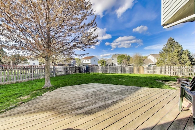 wooden terrace featuring a fenced backyard, a yard, and a residential view