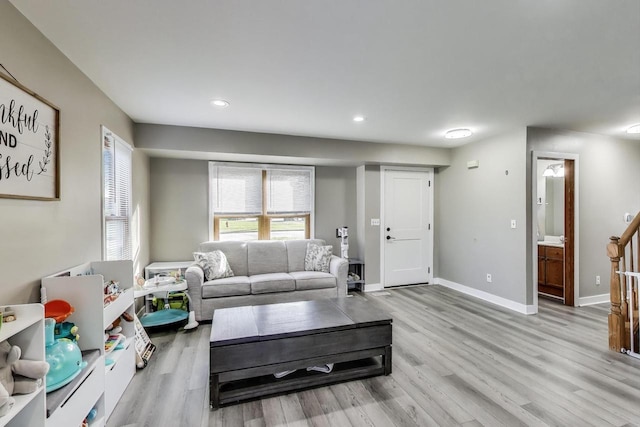 living area featuring recessed lighting, baseboards, and light wood-style floors