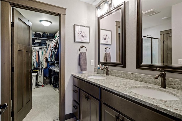 2931 Drier Rd, Eau Claire, WI 54701 - bathroom with double vanity, a sink, a walk in closet, and visible vents