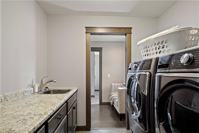 2931 Drier Rd, Eau Claire, WI 54701 - laundry area featuring baseboards, a sink, cabinet space, and washing machine and dryer