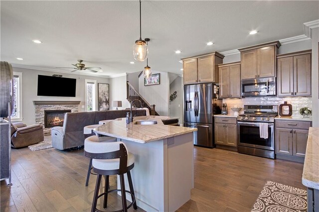 2931 Drier Rd, Eau Claire, WI 54701 - kitchen featuring a breakfast bar area, a ceiling fan, crown molding, a sink, and stainless steel appliances