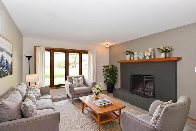 living room featuring a brick fireplace and wood finished floors