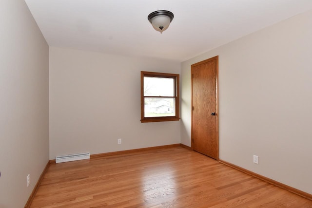 unfurnished room featuring light wood-style flooring, baseboards, and baseboard heating