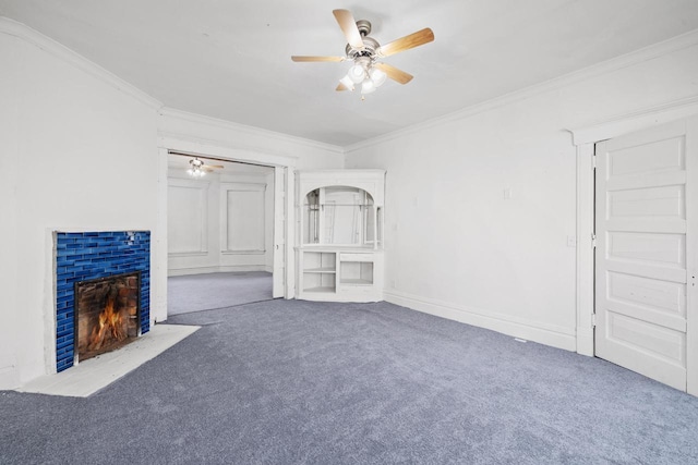 unfurnished living room featuring carpet flooring, a ceiling fan, ornamental molding, and a brick fireplace
