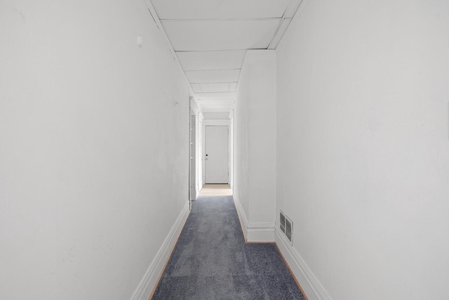 hall featuring baseboards, visible vents, and carpet