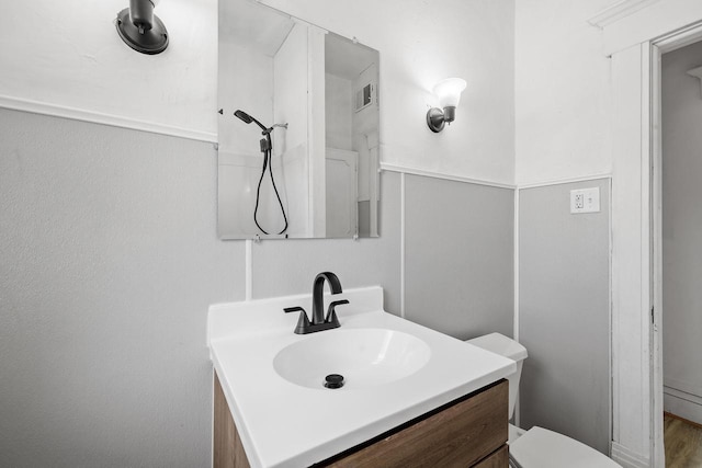 bathroom featuring toilet, visible vents, and vanity