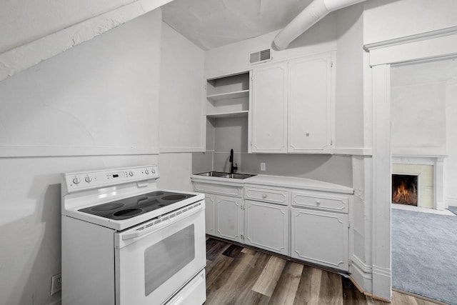 kitchen featuring white range with electric stovetop, open shelves, a sink, white cabinetry, and visible vents