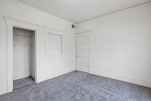 unfurnished bedroom featuring carpet flooring, baseboards, visible vents, and a closet