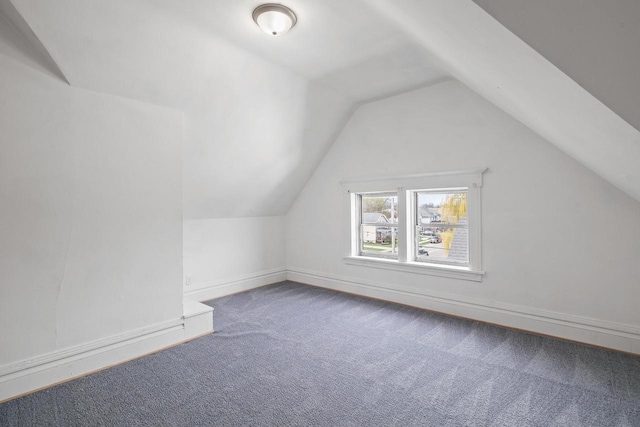 bonus room with carpet floors, baseboards, and vaulted ceiling