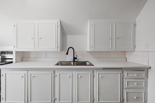 kitchen with stainless steel range with electric cooktop, decorative backsplash, and a sink