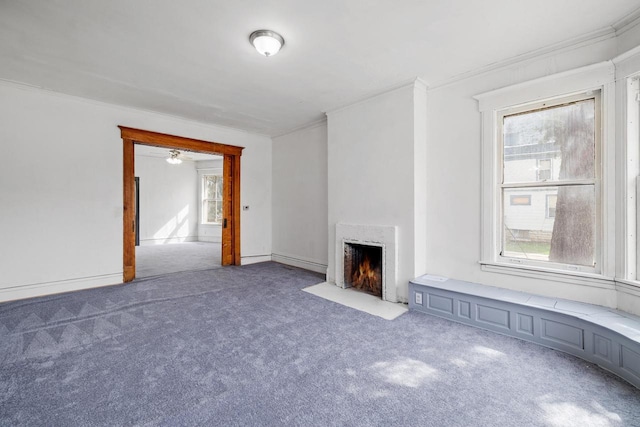 unfurnished living room with a high end fireplace, carpet floors, and ornamental molding