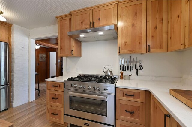 13195 Kavanaugh Rd, Cable, WI 54821 - kitchen with appliances with stainless steel finishes, under cabinet range hood, and light wood-style flooring