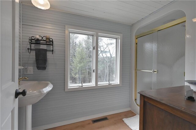 13195 Kavanaugh Rd, Cable, WI 54821 - bathroom with visible vents, wood finished floors, baseboards, wooden ceiling, and a shower with shower door