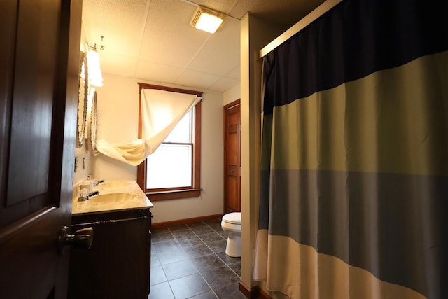147 N James St, Kimberly, WI 54136 - bathroom featuring tile patterned flooring, vanity, toilet, baseboards, and a drop ceiling