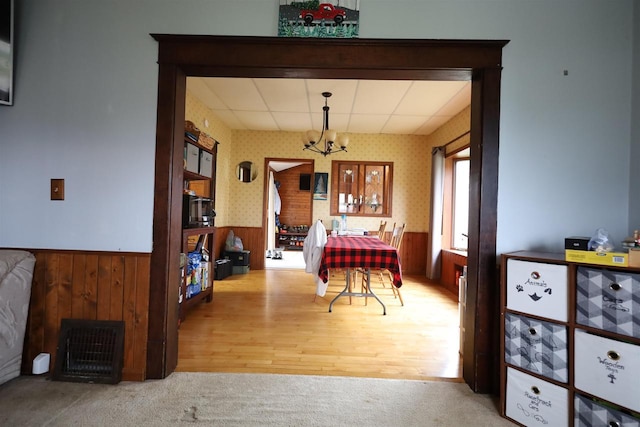 147 N James St, Kimberly, WI 54136 - dining space featuring carpet floors, wooden walls, wallpapered walls, a wainscoted wall, and a notable chandelier