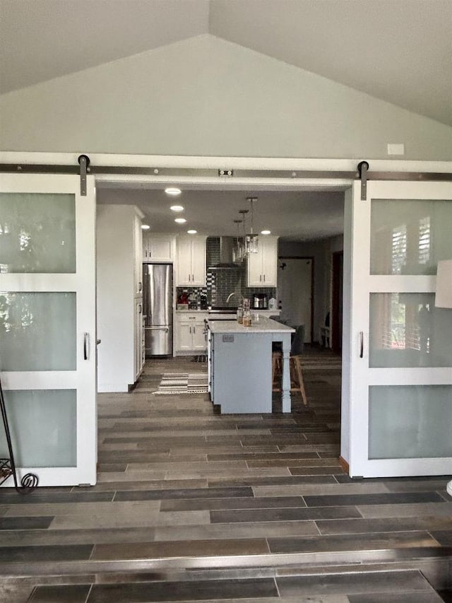 W6517 Greenwood Ct, Greenville, WI 54952 - kitchen featuring a barn door, freestanding refrigerator, vaulted ceiling, white cabinetry, and dark wood-style floors
