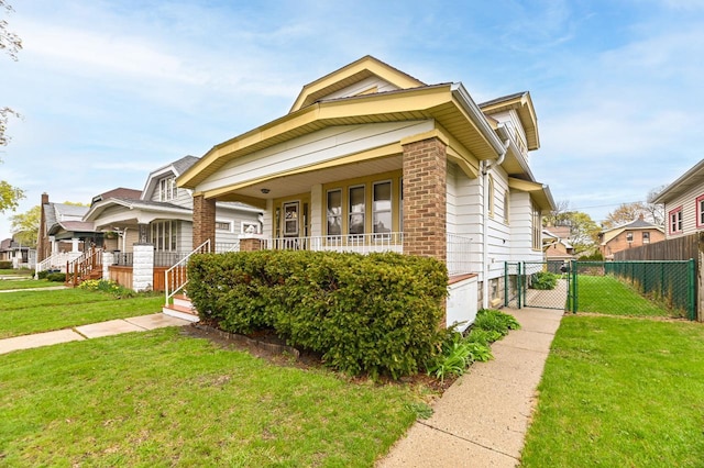 view of front of house featuring a porch, a gate, fence, and a front yard