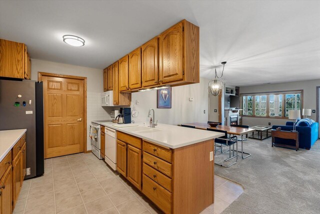 kitchen with brown cabinets, a sink, white appliances, light countertops, and open floor plan