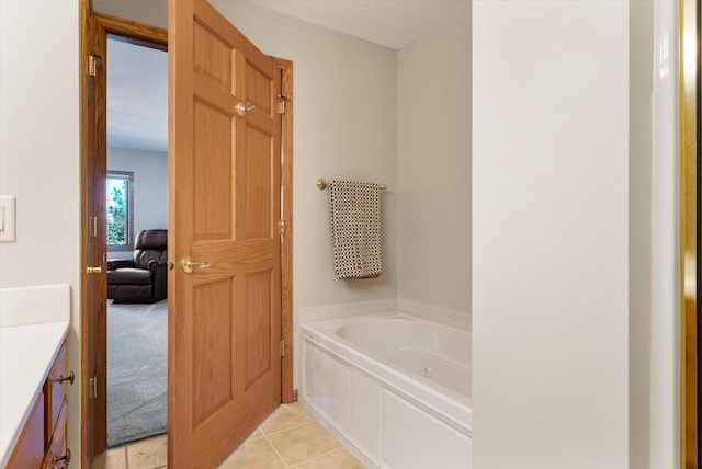 bathroom with tile patterned floors, a garden tub, and vanity