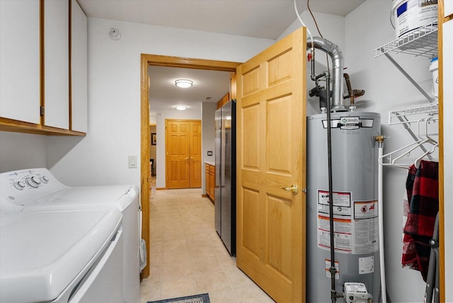 laundry room featuring cabinet space, water heater, light tile patterned floors, and washer and dryer