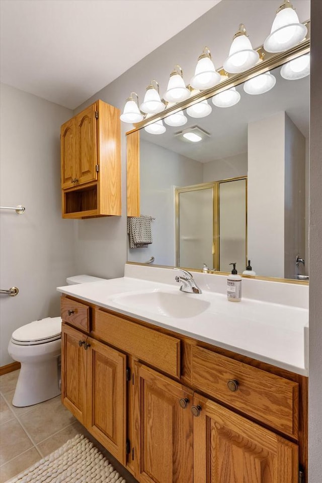 full bath featuring tile patterned flooring, a stall shower, toilet, and vanity