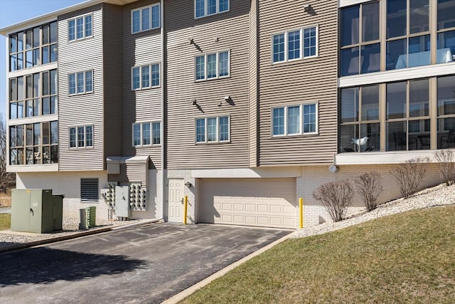 view of building exterior with an attached garage and aphalt driveway