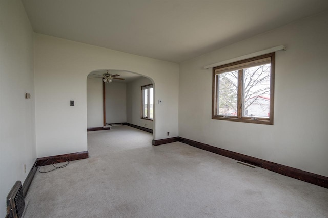 5016 Sth 96, Denmark, WI 54208 - unfurnished room with visible vents, light carpet, baseboards, ceiling fan, and arched walkways