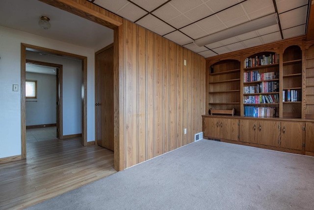 5016 Sth 96, Denmark, WI 54208 - spare room with visible vents, wood walls, light carpet, baseboards, and a drop ceiling