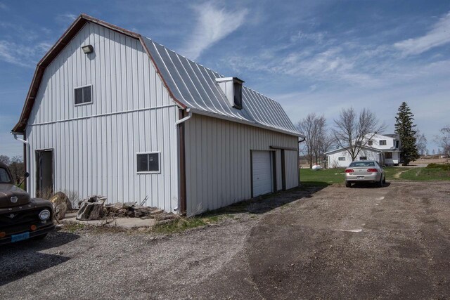 5016 Sth 96, Denmark, WI 54208 - view of side of home featuring metal roof, dirt driveway, an outbuilding, a garage, and a gambrel roof