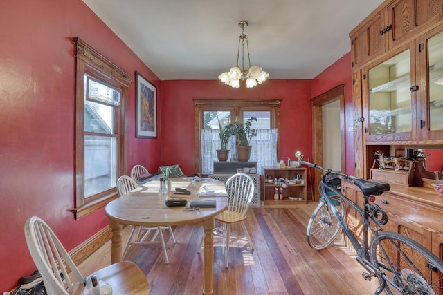 611 N St, West Bend, WI 53090 - dining room with a chandelier, light wood-style flooring, and baseboards