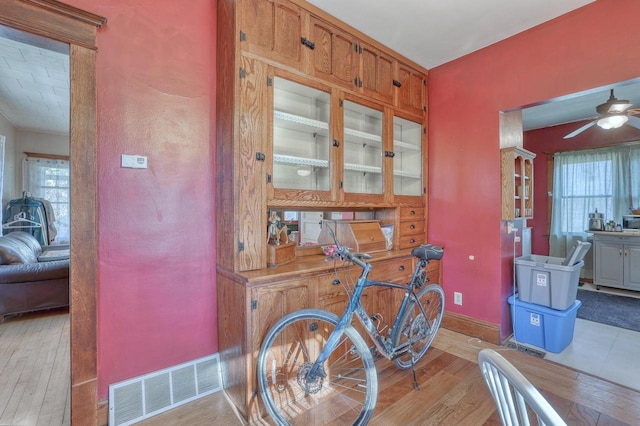 611 N St, West Bend, WI 53090 - bar area featuring light wood-style floors, a ceiling fan, and plenty of natural light