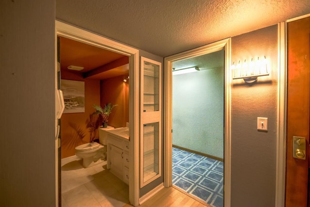 bathroom with vanity, toilet, and a textured ceiling